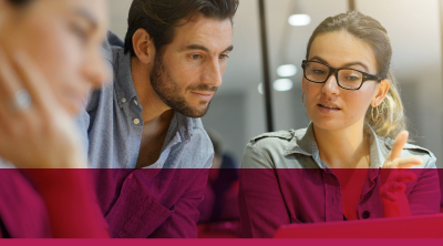 three people engaged with a screen, discussing business concepts