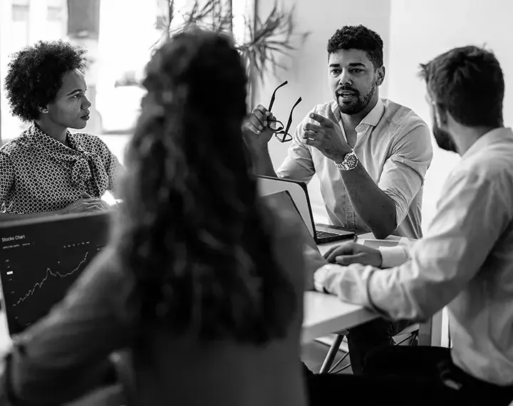 A diverse group of individuals engaged in conversation while seated around a table, fostering collaboration and connection.