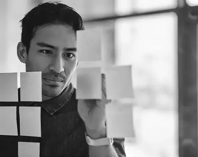 A man attaching a sticker to the window, demonstrating self-leadership